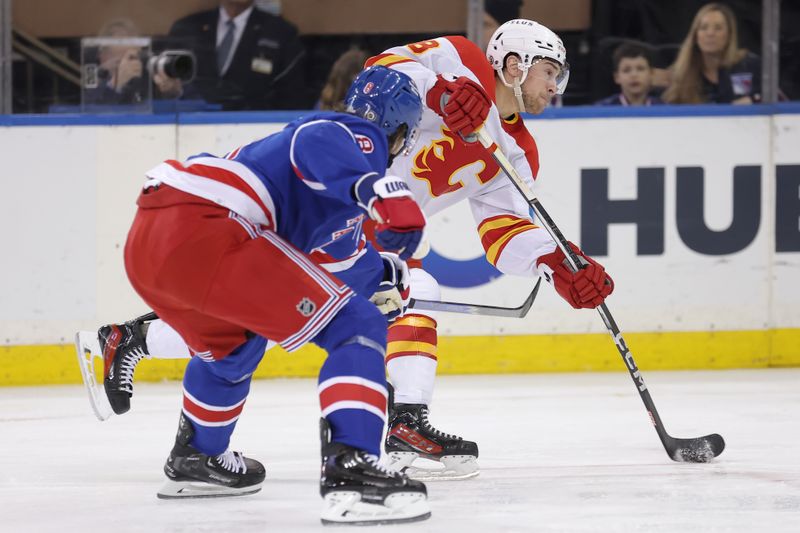 Feb 12, 2024; New York, New York, USA; Calgary Flames left wing Andrew Mangiapane (88) takes a shot against New York Rangers defenseman Jacob Trouba (8) during the second period at Madison Square Garden. Mandatory Credit: Brad Penner-USA TODAY Sports