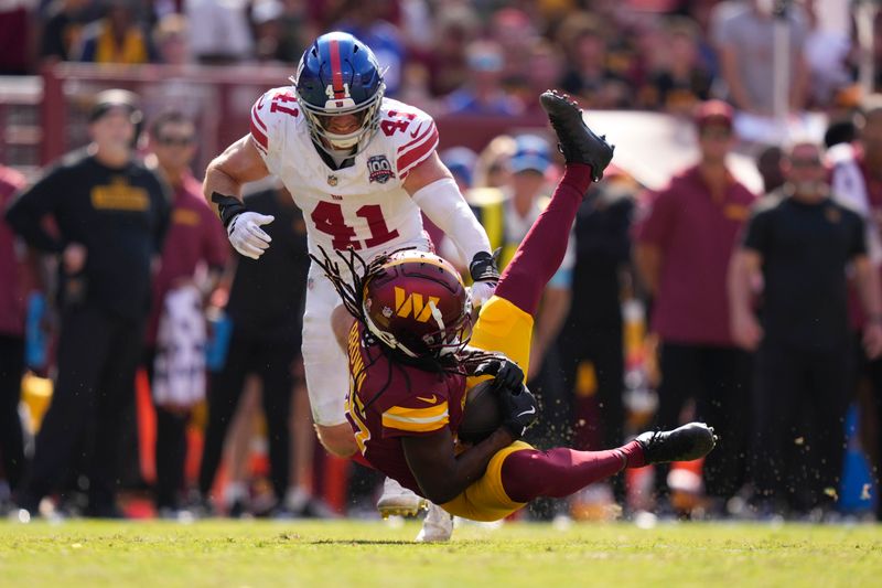 Washington Commanders wide receiver Noah Brown, bottom, catches a pass in front of New York Giants linebacker Micah McFadden, top, during the second half of an NFL football game in Landover, Md., Sunday, Sept. 15, 2024. (AP Photo/Matt Slocum)