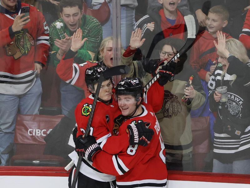 Dec 22, 2023; Chicago, Illinois, USA; Chicago Blackhawks center Ryan Donato (8) celebrates with left wing Lukas Reichel (27) after scoring against the Montreal Canadiens during the first period at United Center. Mandatory Credit: Kamil Krzaczynski-USA TODAY Sports