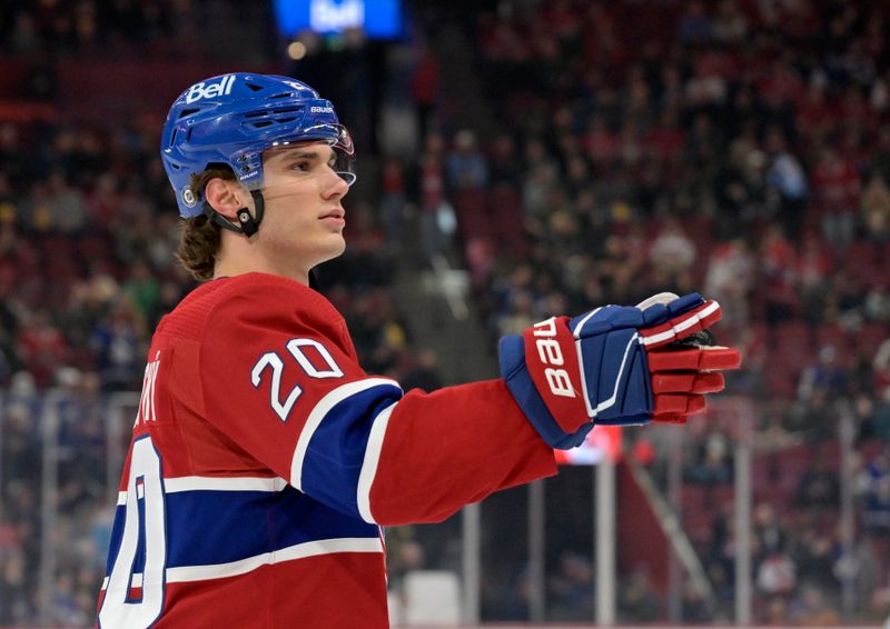 Mar 9, 2024; Montreal, Quebec, CAN; Montreal Canadiens forward Juraj Slafkovsky (20) throws a puck in the stands during the warm up period before the game against the Toronto Maple Leafs at the Bell Centre. Mandatory Credit: Eric Bolte-USA TODAY Sports