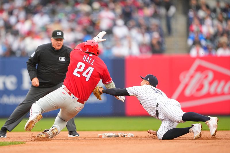 Apr 5, 2023; Bronx, New York, USA; New York Yankees shortstop Anthony Volpe (11) tags out Philadelphia Phillies first baseman Darick Hall (24) trying to stretch a single into a double during the fourth inning at Yankee Stadium. Mandatory Credit: Gregory Fisher-USA TODAY Sports