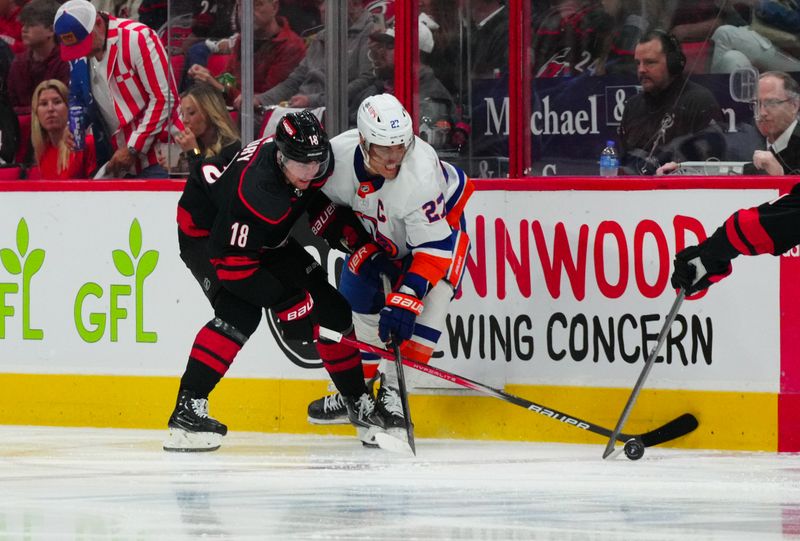 Apr 30, 2024; Raleigh, North Carolina, USA; Carolina Hurricanes center Jack Drury (18) and New York Islanders left wing Anders Lee (27) battle over the puck during the second period in game five of the first round of the 2024 Stanley Cup Playoffs at PNC Arena. Mandatory Credit: James Guillory-USA TODAY Sports