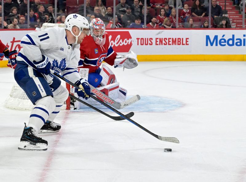 Apr 6, 2024; Montreal, Quebec, CAN; Toronto Maple Leafs forward Max Domi (11) plays the puck and Montreal Canadiens goalie Cayden Primeau (30) defends during the third period at the Bell Centre. Mandatory Credit: Eric Bolte-USA TODAY Sports