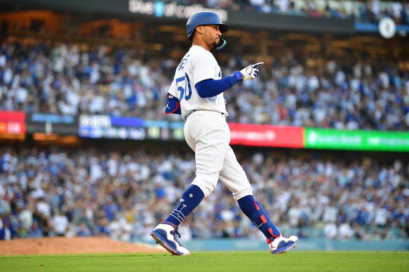 Jun 25, 2023; Los Angeles, California, USA; Los Angeles Dodgers second baseman Mookie Betts (50) reacts after hitting a sacrifice RBI against the Houston Astros during the tenth inning at Dodger Stadium. Mandatory Credit: Gary A. Vasquez-USA TODAY Sports