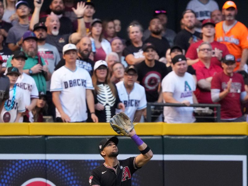 Oct 31, 2023; Phoenix, Arizona, USA; Arizona Diamondbacks left fielder Lourdes Gurriel Jr. (12) makes a catch against the Texas Rangers during the first inning in game four of the 2023 World Series at Chase Field. Mandatory Credit: Joe Camporeale-USA TODAY Sports