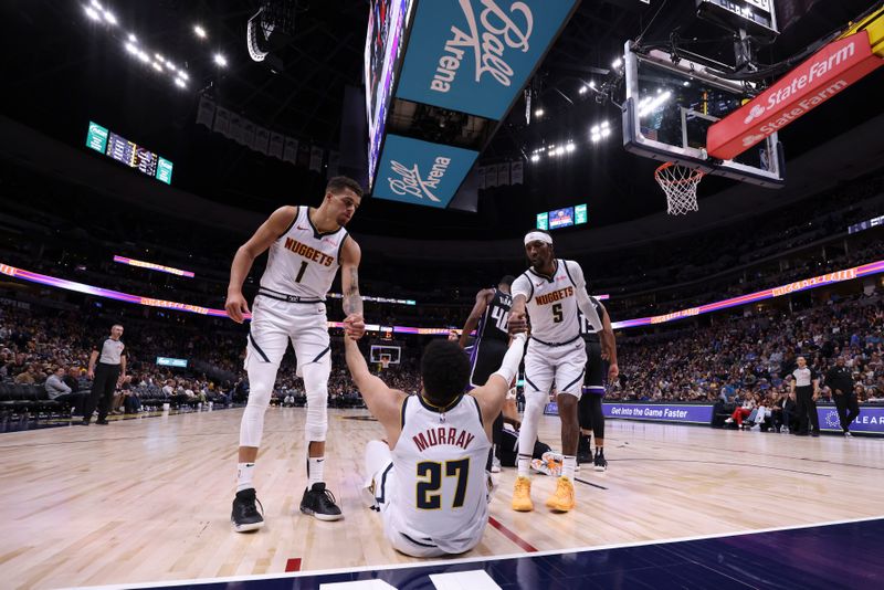 DENVER, COLORADO - FEBRUARY 28: Michael Porter Jr. #1 and Kentavious Caldwell-Pope #5 of the Denver Nuggets help Jamal Murray #27 to his feet during the game against the Sacramento Kings at Ball Arena on February 28, 2024 in Denver, Colorado. NOTE TO USER: User expressly acknowledges and agrees that, by downloading and or using this photograph, User is consenting to the terms and conditions of the Getty Images License Agreement. (Photo by Brendall O'Banon/Clarkson Creative/Getty Images)