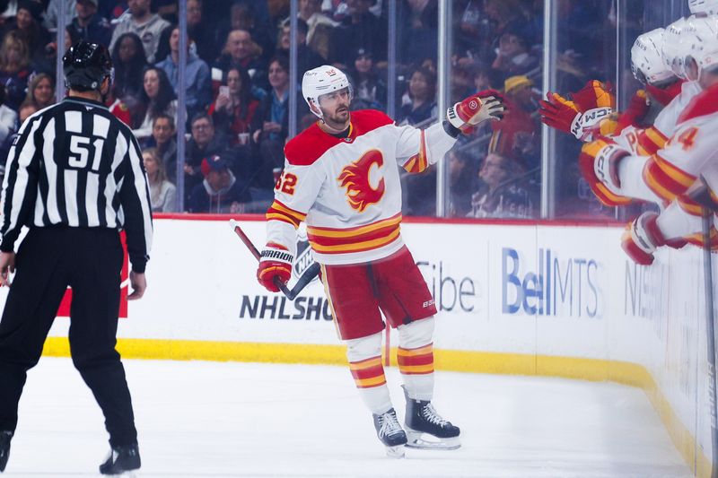 Jan 26, 2025; Winnipeg, Manitoba, CAN; Calgary Flames defenseman MacKenzie Weegar (52) is congratulated by his team mates on his goal against the Winnipeg Jets during the second period at Canada Life Centre. Mandatory Credit: Terrence Lee-Imagn Images