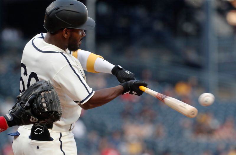 Aug 13, 2023; Pittsburgh, PA, USA; Pittsburgh Pirates second baseman Liover Peguero (60) hits an RBI single against the Cincinnati Reds during the fourth inning at PNC Park. Mandatory Credit: Charles LeClaire-USA TODAY Sports