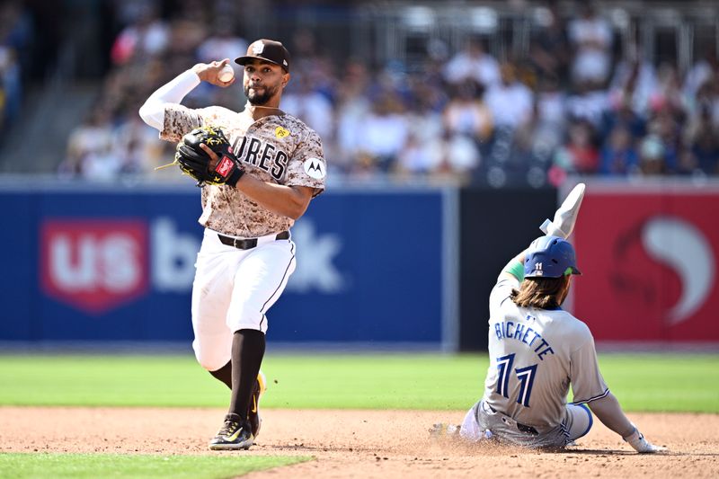 Apr 21, 2024; San Diego, California, USA; San Diego Padres second baseman Xander Bogaerts (left) throws to first base after forcing out Toronto Blue Jays shortstop Bo Bichette (11) at second base to complete a double play to end the game at Petco Park. Mandatory Credit: Orlando Ramirez-USA TODAY Sports