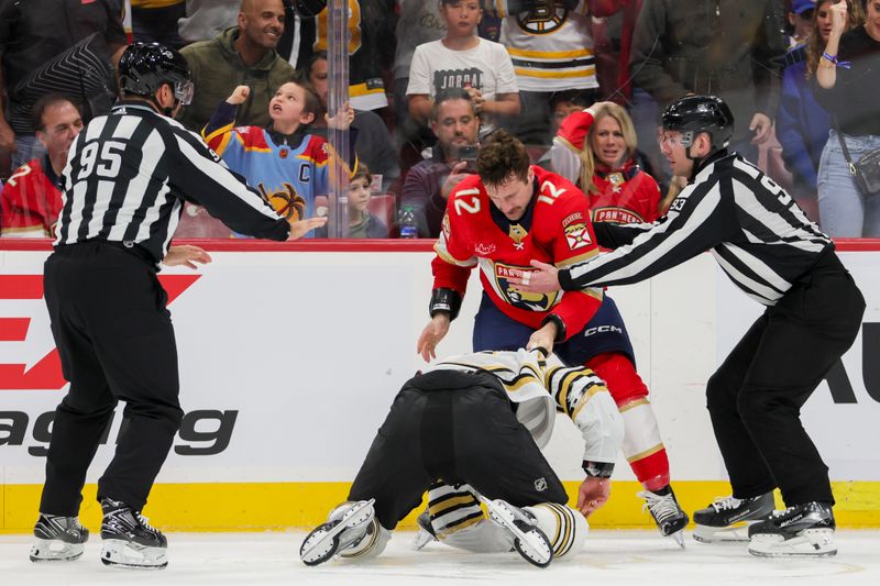 Nov 22, 2023; Sunrise, Florida, USA; Boston Bruins defenseman Derek Forbort (28) and Florida Panthers left wing Jonah Gadjovich (12) fight during the second period at Amerant Bank Arena. Mandatory Credit: Sam Navarro-USA TODAY Sports