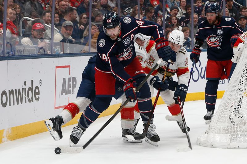 Mar 5, 2026; Columbus, Ohio, USA; Columbus Blue Jackets defenseman Erik Gudbranson (44) picks up a loose puck as Florida Panthers center Anton Lundell (15) trails the play during the first period at Nationwide Arena. Mandatory Credit: Russell LaBounty-Imagn Images