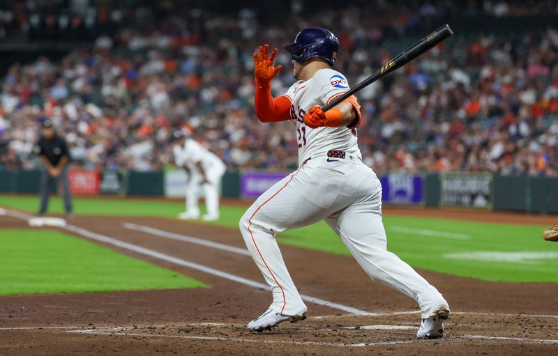 Sep 17, 2025; Houston, Texas, USA; Houston Astros catcher Yainer Diaz (21) hits a two run RBI single against the Texas Rangers in the first inning at Daikin Park. Mandatory Credit: Thomas Shea-Imagn Images