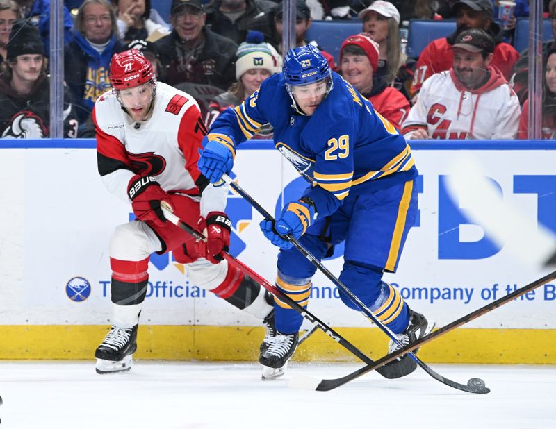 Nov 23, 2025; Buffalo, New York, USA; Buffalo Sabres left wing Beck Malenstyn (29) and Carolina Hurricanes defenseman Alexander Nikishin (21) battle for the puck in the third period at KeyBank Center. Mandatory Credit: Mark Konezny-Imagn Images