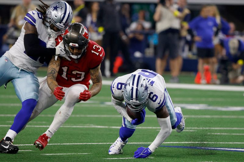 Dallas Cowboys safety Donovan Wilson (6) intercepts a pass intended for Tampa Bay Buccaneers wide receiver Mike Evans (13) as safety Malik Hooker, left, helps defend on the play in the second half of a NFL football game in Arlington, Texas, Sunday, Sept. 11, 2022. (AP Photo/Ron Jenkins)