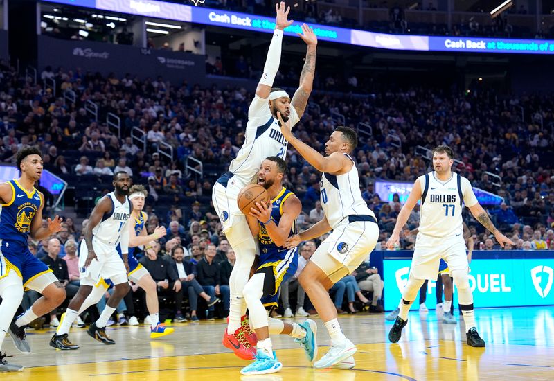 SAN FRANCISCO, CALIFORNIA - APRIL 02: Stephen Curry #30 of the Golden State Warriors drives to the basket on Daniel Gafford #21 and Dante Exum #0 of the Dallas Mavericks during the first half at Chase Center on April 02, 2024 in San Francisco, California. NOTE TO USER: User expressly acknowledges and agrees that, by downloading and or using this photograph, User is consenting to the terms and conditions of the Getty Images License Agreement. (Photo by Thearon W. Henderson/Getty Images)
