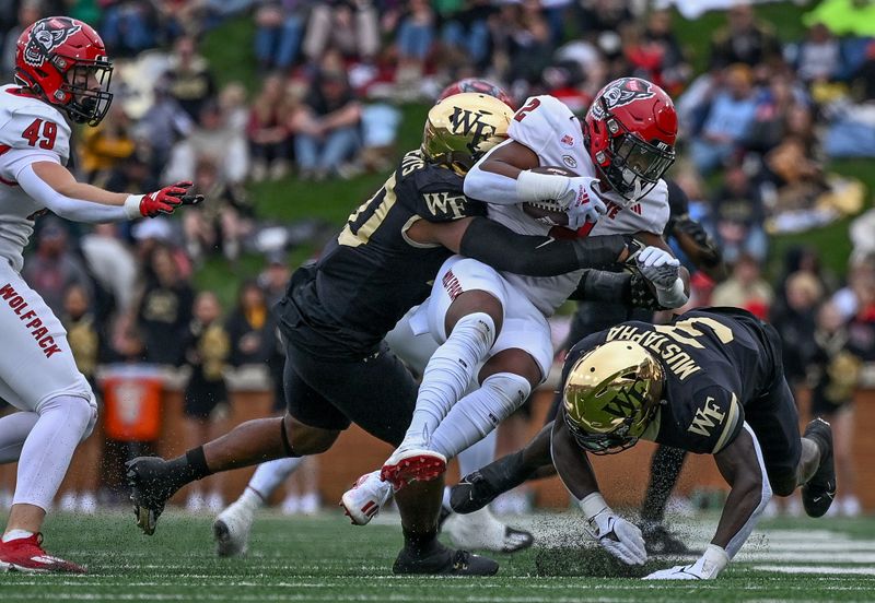 Nov 11, 2023; Winston-Salem, North Carolina, USA; North Carolina State Wolfpack running back Michael Allen (2) is tackled by the Wake Forest Demon Deacons during the first half at Allegacy Federal Credit Union Stadium. Mandatory Credit: William Howard-USA TODAY Sports