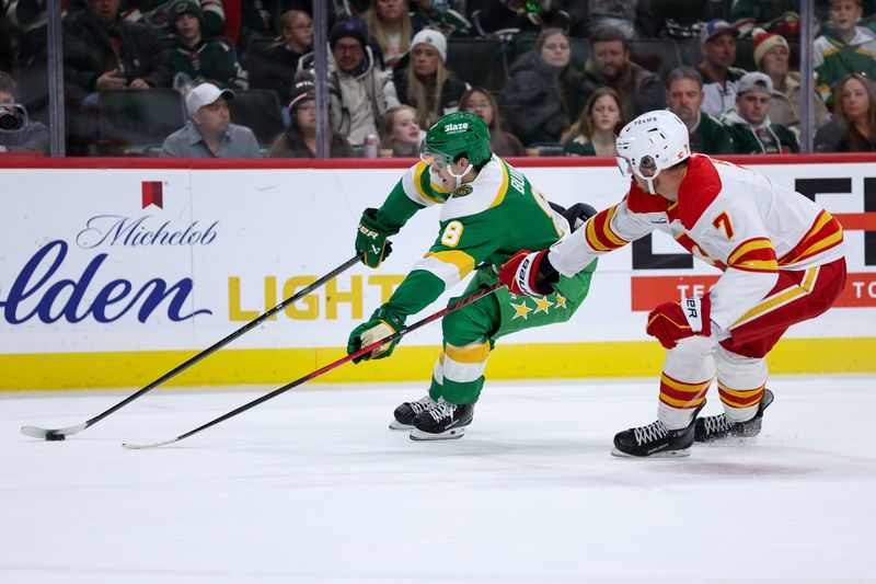 Nov 9, 2025; Saint Paul, Minnesota, USA; Minnesota Wild defenseman Zeev Buium (8) skates with the puck alongside Calgary Flames defenseman Kevin Bahl (7) during the second period at Grand Casino Arena. Mandatory Credit: Matt Krohn-Imagn Images