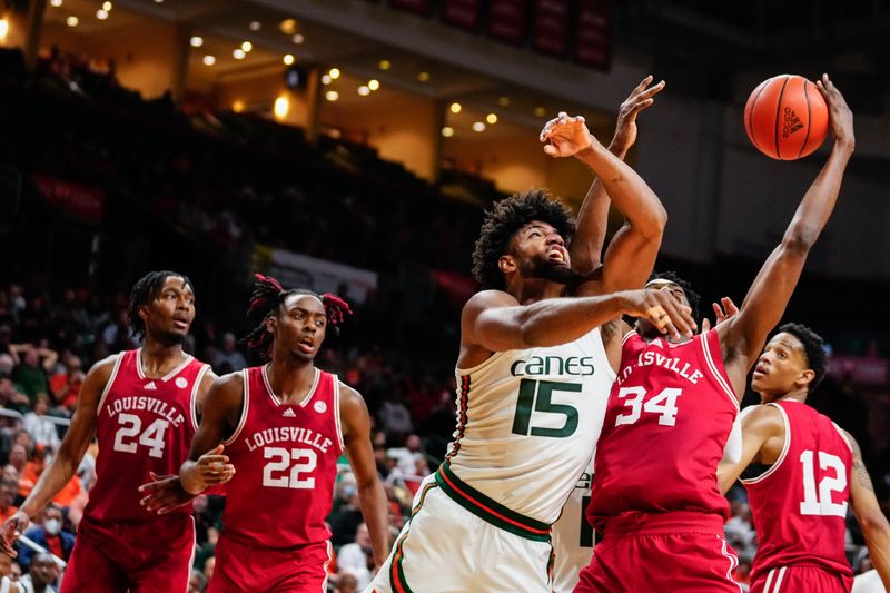 Feb 11, 2023; Coral Gables, Florida, USA; Miami (Fl) Hurricanes forward Norchad Omier (15) and Louisville Cardinals forward Emmanuel Okorafor (34) compete for a rebound during the second half at Watsco Center. Mandatory Credit: Rich Storry-USA TODAY Sports