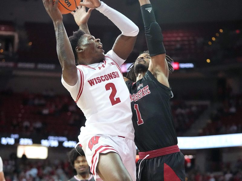 Nov 6, 2023; Madison, Wisconsin, USA;  Wisconsin Badgers guard AJ Storr (2) scores under coverage by Arkansas State Red Wolves forward LaQuill Hardnett (1) during the second half at the Kohl Center. Mandatory Credit: Kayla Wolf-USA TODAY Sports