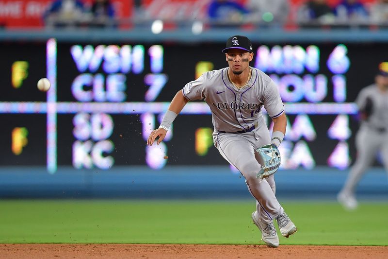 May 31, 2024; Los Angeles, California, USA; Colorado Rockies shortstop Ezequiel Tovar (14) fields the ground ball of Los Angeles Dodgers catcher Will Smith (16) during the ninth inning at Dodger Stadium. Mandatory Credit: Gary A. Vasquez-USA TODAY Sports