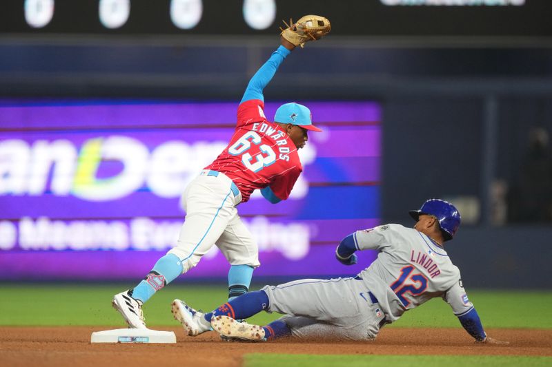 Jul 20, 2024; Miami, Florida, USA;  Miami Marlins shortstop Xavier Edwards (63) gets the force out as New York Mets shortstop Francisco Lindor (12) slides into second base in the first inning at loanDepot Park. Mandatory Credit: Jim Rassol-USA TODAY Sports