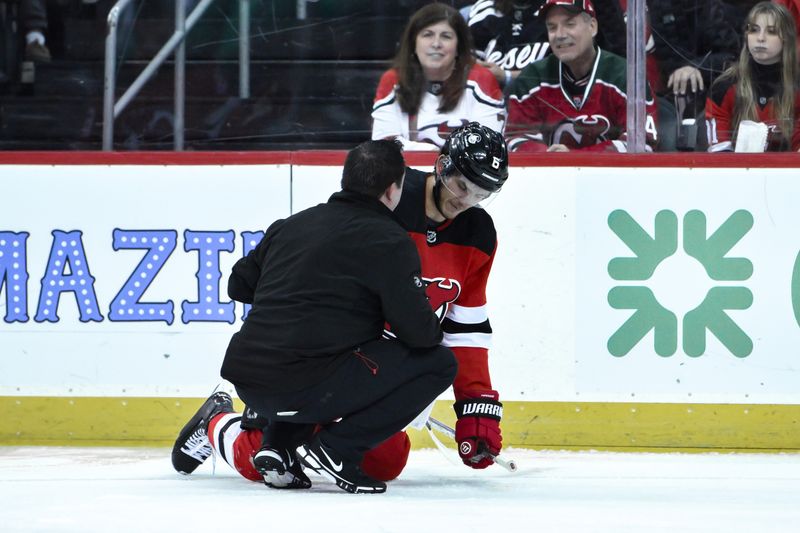 Feb 12, 2024; Newark, New Jersey, USA; New Jersey Devils defenseman John Marino (6) receives medical attention after being checked during the first period against the Seattle Kraken at Prudential Center. Mandatory Credit: John Jones-USA TODAY Sports