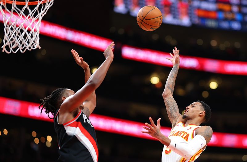 ATLANTA, GEORGIA - MARCH 27:  Dejounte Murray #5 of the Atlanta Hawks attempts a shot against Jabari Walker #34 of the Portland Trail Blazers during the fourth quarter at State Farm Arena on March 27, 2024 in Atlanta, Georgia.  NOTE TO USER: User expressly acknowledges and agrees that, by downloading and/or using this photograph, user is consenting to the terms and conditions of the Getty Images License Agreement.  (Photo by Kevin C. Cox/Getty Images)