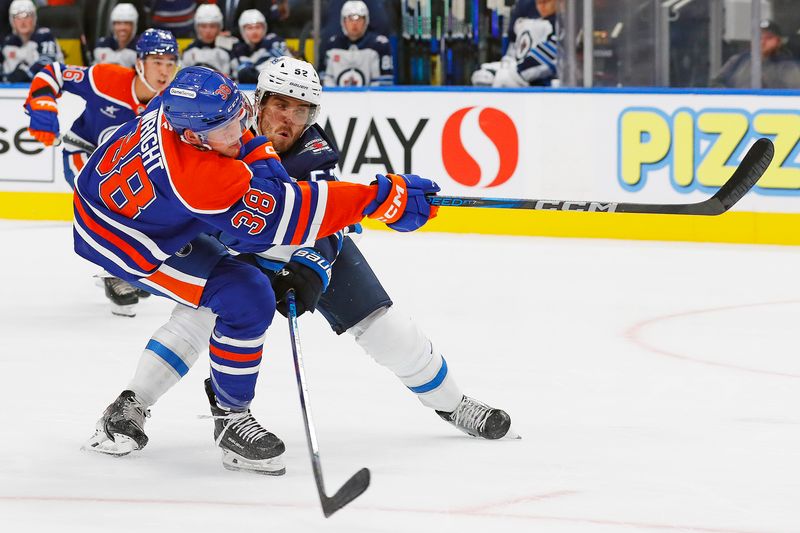 Sep 22, 2024; Edmonton, Alberta, CAN; Edmonton Oilers forward Cam Wright (38) takes a shot in front of Winnipeg Jets defensemen Dylan Coghlan (52) during the third period at Rogers Place. Mandatory Credit: Perry Nelson-Imagn Images