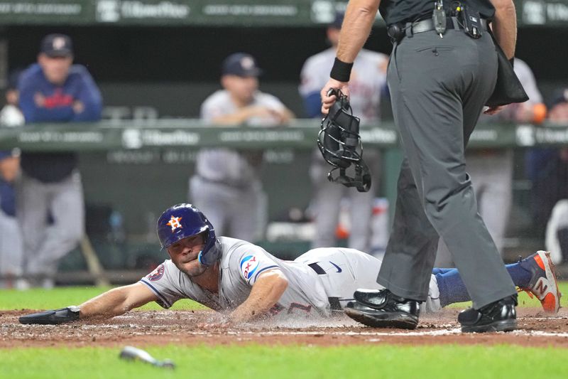 Aug 22, 2024; Baltimore, Maryland, USA; Houston Astros second baseman Jose Altuve (27) slides in safely to score during the fourth inning against the Baltimore Orioles at Oriole Park at Camden Yards. Mandatory Credit: Mitch Stringer-USA TODAY Sports