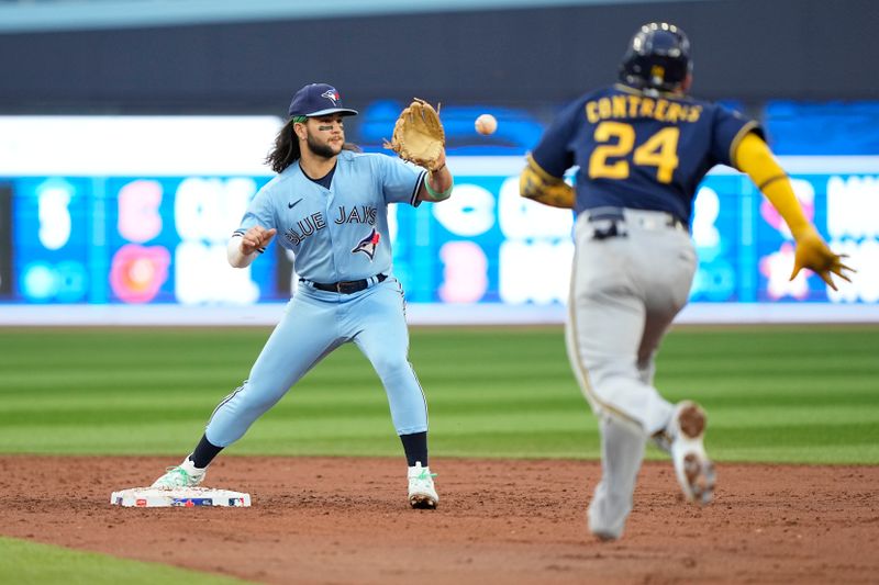 May 30, 2023; Toronto, Ontario, CAN; Toronto Blue Jays shortstop Bo Bichette (11) makes a catch at second base to start a double play against Milwaukee Brewers catcher William Contreras (24) and left fielder Christian Yelich (not pictured) during the third inning at Rogers Centre. Mandatory Credit: John E. Sokolowski-USA TODAY Sports