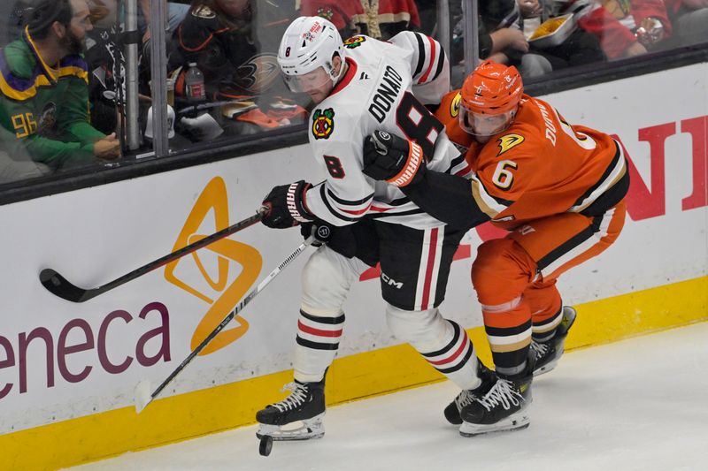 Nov 3, 2024; Anaheim, California, USA;  Chicago Blackhawks center Ryan Donato (8) and Anaheim Ducks defenseman Brian Dumoulin (6) battle along the boards in the first period at Honda Center. Mandatory Credit: Jayne Kamin-Oncea-Imagn Images