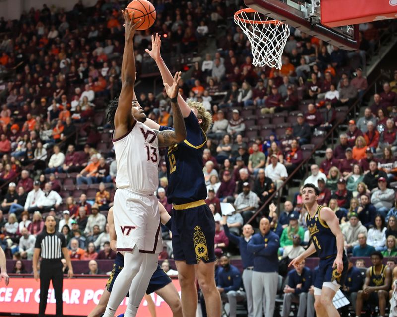 Jan 17, 2026; Blacksburg, Virginia, USA; Virginia Tech Hokies forward Amani Hansberry (13) shoots a shot as Notre Dame Fighting Irish forward Garrett Sundra (12) defends during the first half at Cassell Coliseum. Mandatory Credit: Brian Bishop-Imagn Images