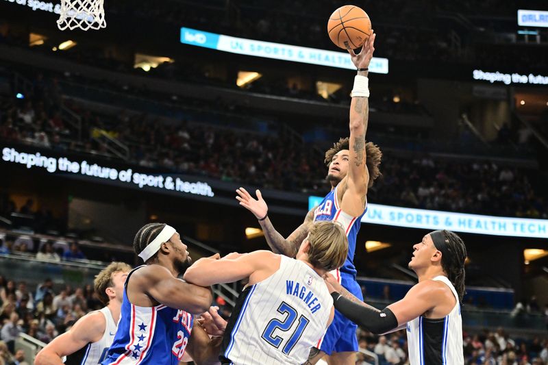 ORLANDO, FLORIDA - OCTOBER 18: Kelly Oubre Jr. #9 of the Philadelphia 76ers shoots a basket over Moritz Wagner #21 and Paolo Banchero #5 of the Orlando Magic in the first half of a game at Kia Center on October 18, 2024 in Orlando, Florida. NOTE TO USER: User expressly acknowledges and agrees that, by downloading and or using this photograph, User is consenting to the terms and conditions of the Getty Images License Agreement. (Photo by Julio Aguilar/Getty Images)