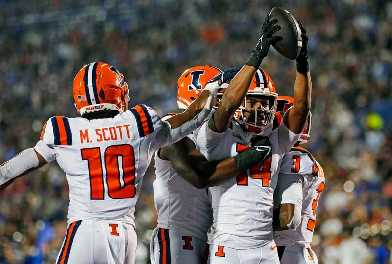 Sep 8, 2023; Lawrence, Kansas, USA; Illinois Fighting Illini defensive back Xavier Scott (14) celebrates with teammates after an interception during the second half against the Kansas Jayhawks at David Booth Kansas Memorial Stadium. Mandatory Credit: Jay Biggerstaff-USA TODAY Sports