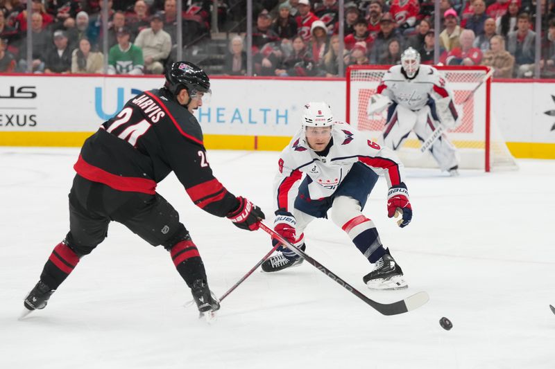 Nov 11, 2025; Raleigh, North Carolina, USA;  Carolina Hurricanes center Seth Jarvis (24) skates with the puck in front of Washington Capitals defenseman Jakob Chychrun (6) during the first period at Lenovo Center. Mandatory Credit: James Guillory-Imagn Images