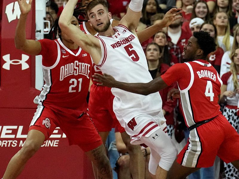 Feb 13, 2024; Madison, Wisconsin, USA; Wisconsin Badgers forward Tyler Wahl (5) is double-teamed by Ohio State Buckeyes forward Devin Royal (21) and guard Dale Bonner (4) during the first half at the Kohl Center in Madison, Wisconsin. Mandatory Credit: Mark Hoffman-USA TODAY Sports