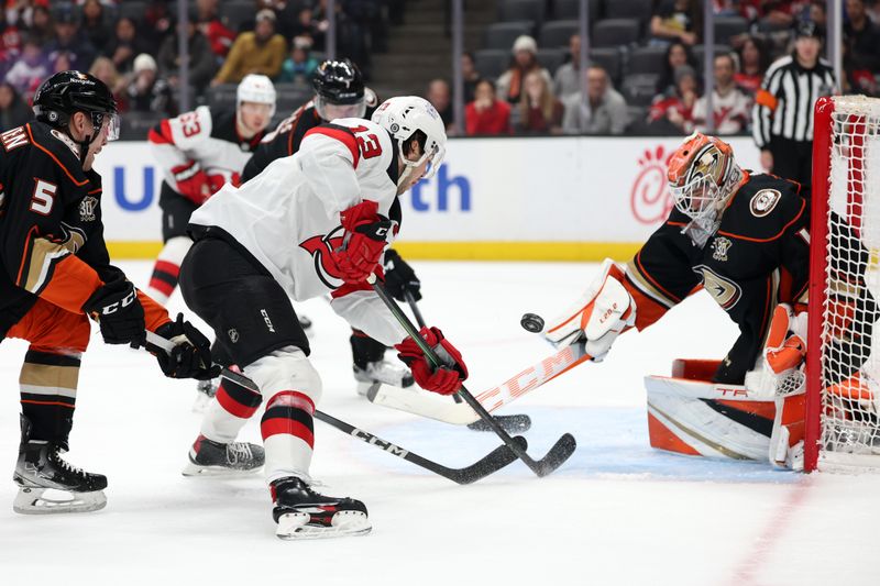 Mar 1, 2024; Anaheim, California, USA; New Jersey Devils center Nico Hischier (13) shoots the puck against Anaheim Ducks goaltender Lukas Dostal (1) during the first period at Honda Center. Mandatory Credit: Kiyoshi Mio-USA TODAY Sports