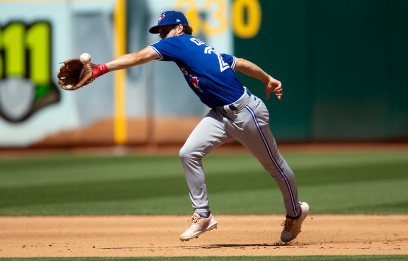 Sep 6, 2023; Oakland, California, USA; Toronto Blue Jays shortstop Ernie Clement (28) misses fielding the single of Oakland Athletics third baseman Kevin Smith during the fourth inning at Oakland-Alameda County Coliseum. Mandatory Credit: D. Ross Cameron-USA TODAY Sports