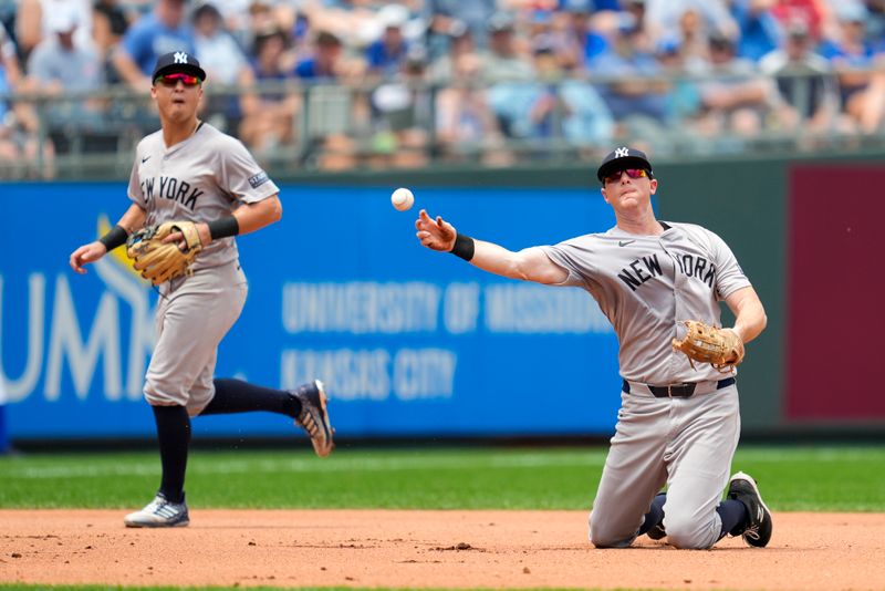 Jun 13, 2024; Kansas City, Missouri, USA; New York Yankees third baseman DJ LeMahieu (26) throws to first base as shortstop Anthony Volpe (11) looks on during the fourth inning against the Kansas City Royals at Kauffman Stadium. Mandatory Credit: Jay Biggerstaff-USA TODAY Sports