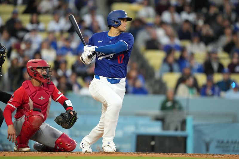 Mar 25, 2024; Los Angeles, California, USA; Los Angeles Dodgers designated hitter Shohei Ohtani (17) bats in the third inning as Los Angeles Angels catcher Logan O'Hoppe (14) watches at Dodger Stadium. Mandatory Credit: Kirby Lee-USA TODAY Sports