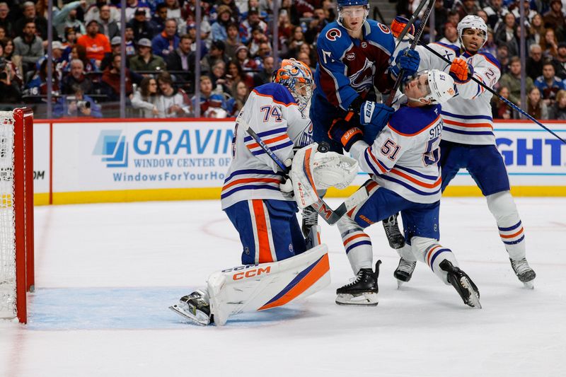 Jan 16, 2025; Denver, Colorado, USA; Edmonton Oilers goaltender Stuart Skinner (74) makes a save as Colorado Avalanche center Parker Kelly (17) collides with defenseman Troy Stecher (51) as  at Ball Arena. Mandatory Credit: Isaiah J. Downing-Imagn Images