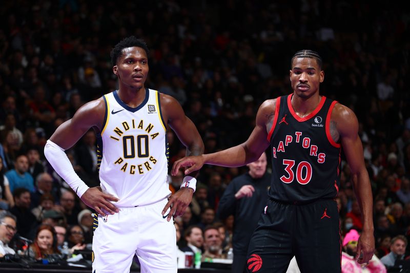 TORONTO, CANADA - DECEMBER 3: Bennedict Mathurin #00 of the Indiana Pacers and Ochai Agbaji #30 of the Toronto Raptors looks on during the game during the Emirates NBA Cup game on December 3, 2024 at the Scotiabank Arena in Toronto, Ontario, Canada.  NOTE TO USER: User expressly acknowledges and agrees that, by downloading and or using this Photograph, user is consenting to the terms and conditions of the Getty Images License Agreement.  Mandatory Copyright Notice: Copyright 2024 NBAE (Photo by Vaughn Ridley/NBAE via Getty Images)