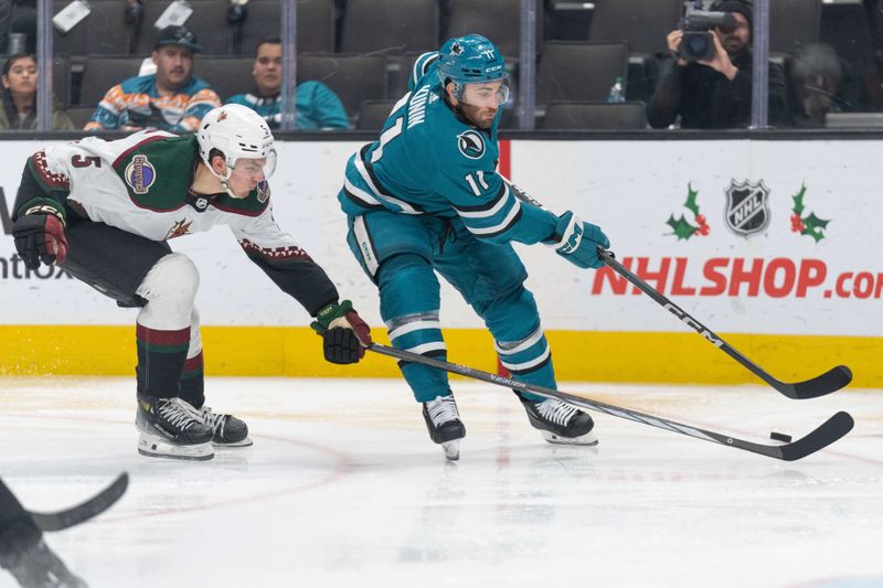 Dec 21, 2023; San Jose, California, USA; Arizona Coyotes defenseman Michael Kesselring (5) attempts to defend against San Jose Sharks center Luke Kunin (11) during the second period at SAP Center at San Jose. Mandatory Credit: Stan Szeto-USA TODAY Sports