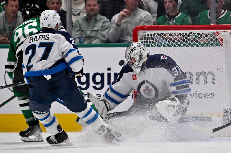 Apr 10, 2025; Dallas, Texas, USA; Winnipeg Jets goaltender Connor Hellebuyck (37) stops a breakaway shot by Dallas Stars right wing Mikko Rantanen (96) during the third period at the American Airlines Center. Mandatory Credit: Jerome Miron-Imagn Images