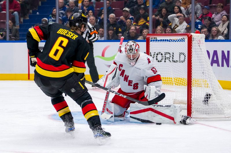 Oct 28, 2024; Vancouver, British Columbia, CAN; Carolina Hurricanes goalie Pyotr Kochetkov (52) makes a save on Vancouver Canucks forward Brock Boeser (6) during the third period at Rogers Arena. Mandatory Credit: Bob Frid-Imagn Images