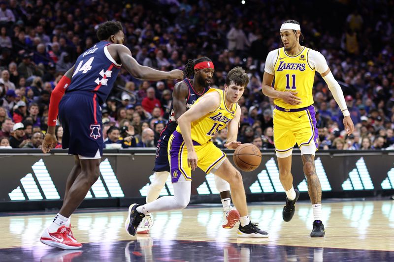 PHILADELPHIA, PENNSYLVANIA - NOVEMBER 27: Austin Reaves #15 of the Los Angeles Lakers dribbles between Paul Reed #44  and Patrick Beverley #22 of the Philadelphia 76ers during the fourth quarter at the Wells Fargo Center on November 27, 2023 in Philadelphia, Pennsylvania. NOTE TO USER: User expressly acknowledges and agrees that, by downloading and or using this photograph, User is consenting to the terms and conditions of the Getty Images License Agreement. (Photo by Tim Nwachukwu/Getty Images)