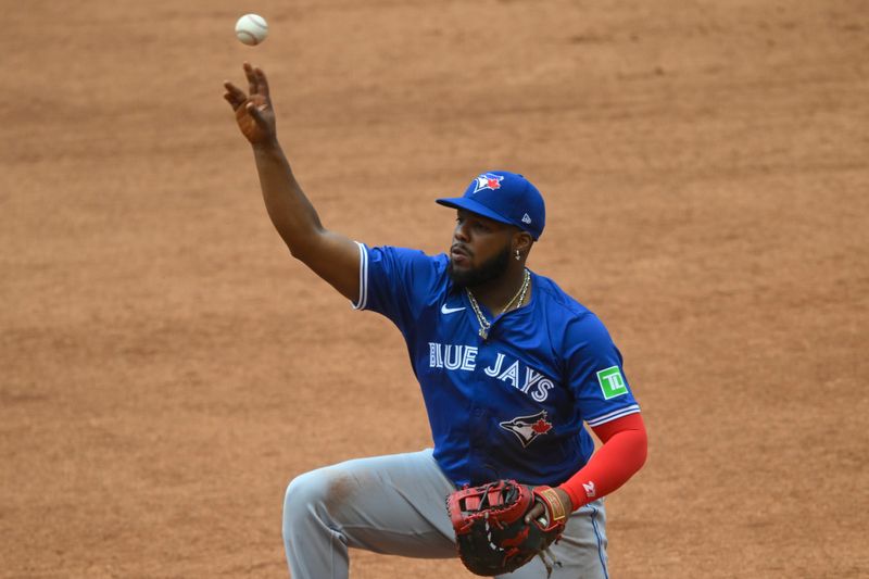 Jun 23, 2024; Cleveland, Ohio, USA; Toronto Blue Jays first baseman Vladimir Guerrero Jr. (27) throws to first base in the third inning against the Cleveland Guardians at Progressive Field. Mandatory Credit: David Richard-USA TODAY Sports