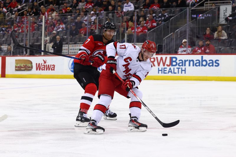 Nov 21, 2024; Newark, New Jersey, USA; Carolina Hurricanes right wing Andrei Svechnikov (37) skates with the puck against New Jersey Devils defenseman Dougie Hamilton (7) during the first period at Prudential Center. Mandatory Credit: Ed Mulholland-Imagn Images