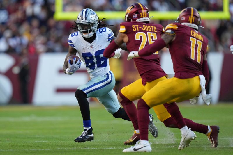 Dallas Cowboys wide receiver CeeDee Lamb (88) runs with the football as Washington Commanders cornerback Benjamin St-Juste (25) and safety Jeremy Chinn (11) try to tackle during the second half of an NFL football game, Sunday, Nov. 24, 2024, in Landover, Md. (AP Photo/Stephanie Scarbrough)