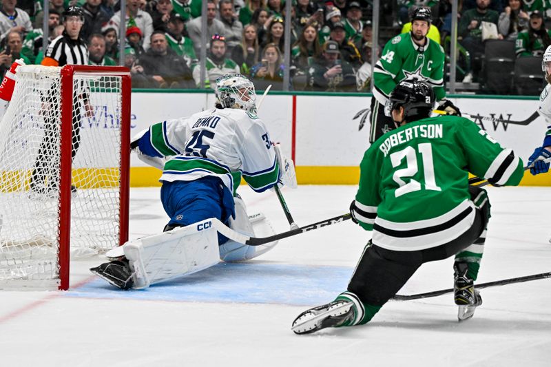 Dec 21, 2023; Dallas, Texas, USA; Dallas Stars left wing Jason Robertson (21) misses the net on a shot against Vancouver Canucks goaltender Thatcher Demko (35) during the second period at the American Airlines Center. Mandatory Credit: Jerome Miron-USA TODAY Sports